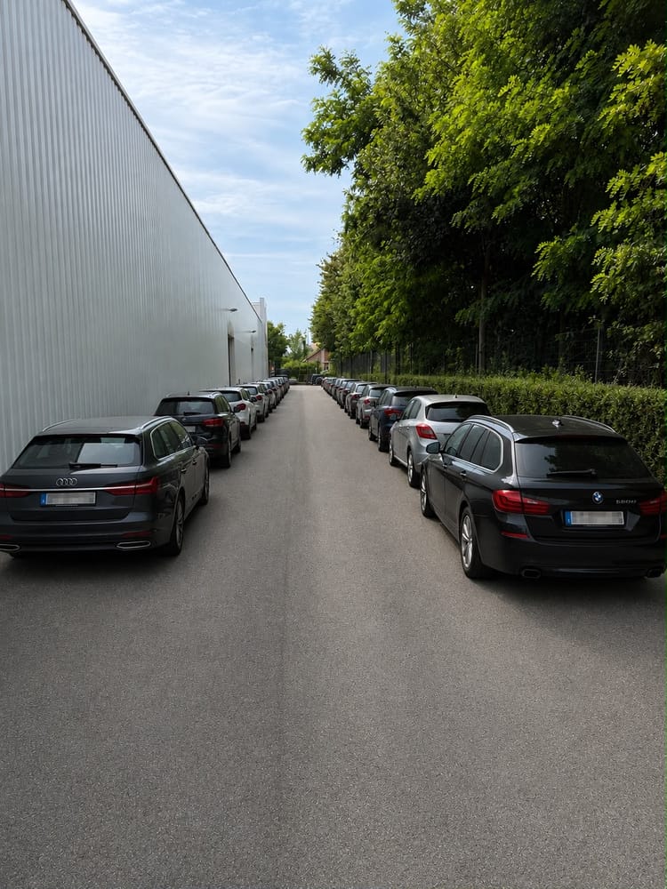 Allée extérieure de voitures le long d'une haie sur site clôturé, parking aéroport Zaventem près de Brussels Zaventem Airport